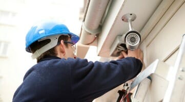 security camera installer on building